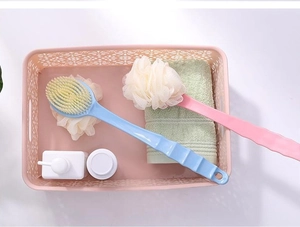 Detail of pink and blue long-handle bath brushes with nylon bristles in a storage basket