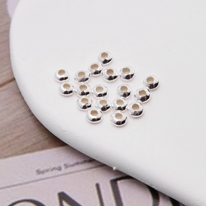 Macro shot of silver spacer beads for DIY jewelry making on white background