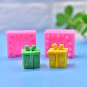 Pink silicone mold and finished gift box candles with bows and embossed dots