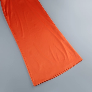 Detail of orange-red silky halter dress showing smooth fabric and premium texture