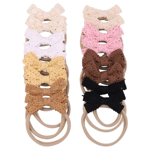 Detailed set of 12 lace bow nylon headbands in multiple neutral colors for infants