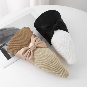 Detail of color-block straw sun hats with satin bows and intricate woven texture