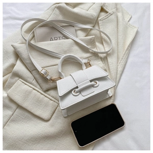Flat lay of white square handbag with top handle and decorative drawstring detail