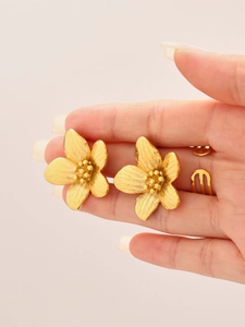 Detailaufnahme von 18K vergoldeten Blumenohrringen mit gebürsteter Metalltextur