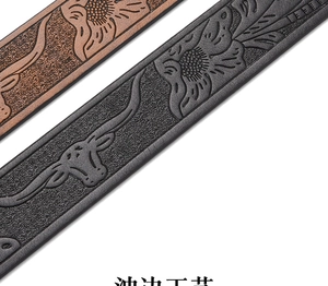 Macro view of embossed floral and bull skull patterns on brown and black leather belts