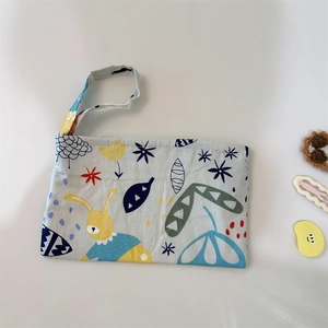 Détail d'une pochette en coton à dragonne avec imprimés lapin mignon et motifs floraux