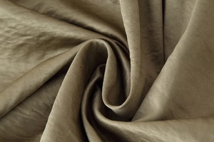 Macro detail of the smooth olive green satin fabric with delicate wrinkled texture