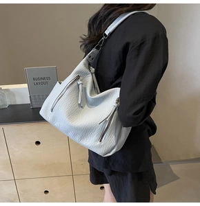 Detail of off-white lychee pattern leather tote bag shown on model for size and fit
