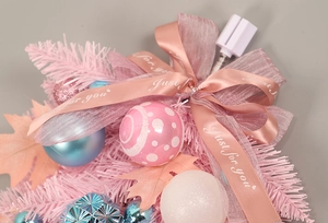 Dettaglio di ghirlanda natalizia rosa con palline blu e decorazione con fiocco