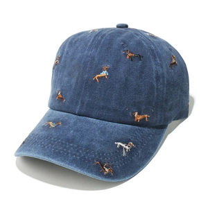 Detail of embroidered dachshund patterns on washed navy blue cotton baseball cap texture