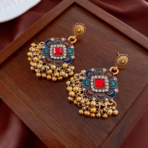 Detailansicht der Vintage-Ohrringe mit Blumenmuster, roten Edelsteinen und Quasten