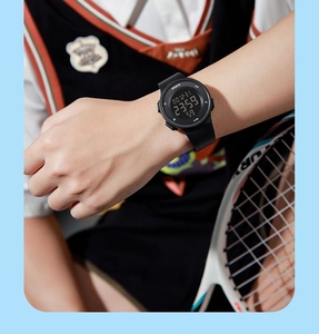 Close-up of black 5ATM waterproof digital sports watch worn on wrist during tennis play