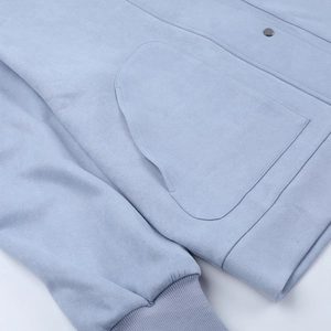 Detail of light blue jacket showing suede texture and ribbed knitted cuffs and pockets