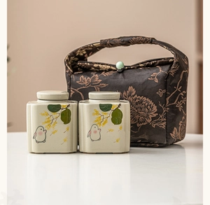 Detail of travel tea set with hand-painted ceramic jars and a patterned fabric carry bag