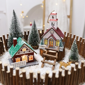 Lighted Christmas wooden house scene with reindeer and snowy pines on display