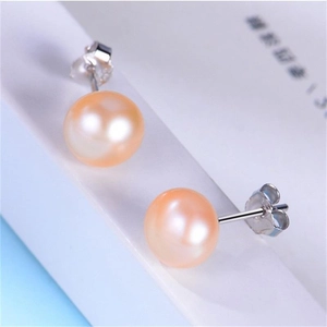 Macro shot of natural orange-pink freshwater pearl earrings with S925 silver studs