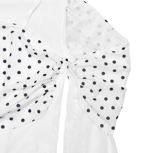 Detailed view of white polka dot sheer mesh fabric with elegant bow knot styling