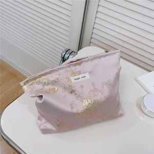 Gros plan du tissu jacquard floral rose et étiquette simple wish sur la trousse de toilette