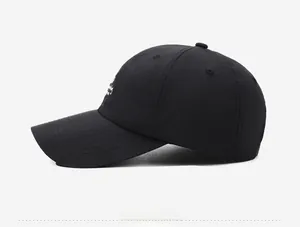 Side view of black quick-dry baseball cap with white embroidery and curved brim