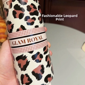 Detail of trendy leopard print insulated cup with houndstooth band and GLAM ROYAL logo