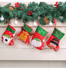 Detail von vier roten Weihnachtsstrümpfen mit 3D-Weihnachtsmann, Hirsch und Schneemann-Motiven