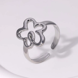 Macro shot of polished silver hollow flower ring with elegant open adjustable band design