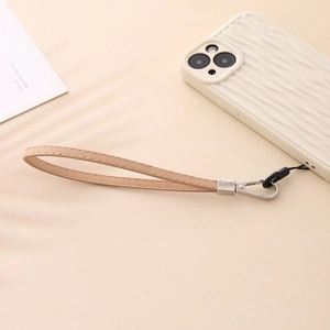 Beige PU leather phone wrist strap with silver metal clasp on a matching phone case