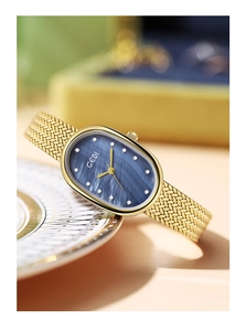 Close-up of luxury gold mesh strap watch with blue mother of pearl dial and crystal markers