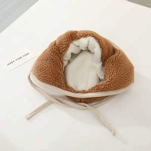 Detail view of lion earflap hat with thick faux sheepskin lining and knit drawstring