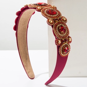 Macro detail of wine red headband featuring sparkling rhinestones and gold beadwork
