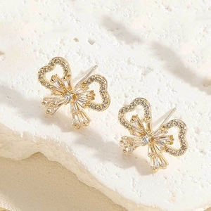 Detailed macro view of golden butterfly earrings featuring sparkling zircon stone inlay
