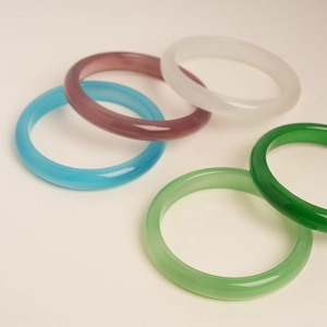 Detailed macro view of smooth cat eye stone bangles in five vibrant assorted colors
