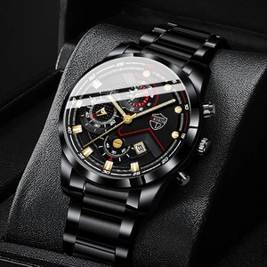 Detailed close-up of a men's black stainless steel watch with gold accents and calendar