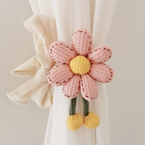 Macro shot of pink waffle fabric flower tieback securing a white curtain in a nursery
