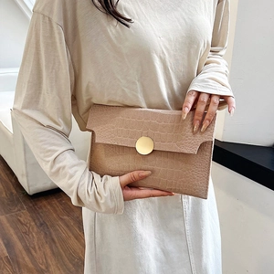 Minimalist beige crocodile embossed envelope clutch bag with large gold metal buckle