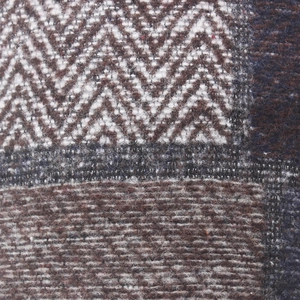 Macro shot of the brown and white wool blend fabric with detailed herringbone pattern