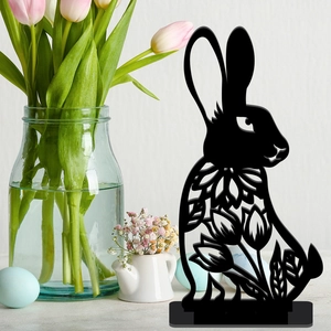Detail view of a black hollow rabbit silhouette with floral patterns on a desktop base