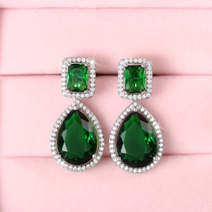 Macro view of teardrop emerald-green stones and micro-pave crystals on drop earrings
