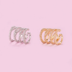 Detailed view of layered gold and silver ear cuffs with pavé-set round white zircons