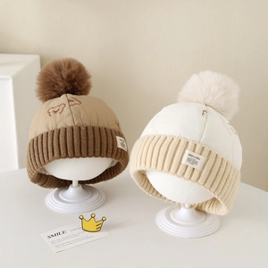 Détails de la maille et pompon sur le bonnet d'hiver brodé pour enfant