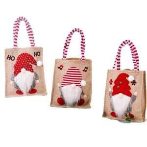 Three Christmas burlap gift bags featuring 3D gnome designs with red striped handles