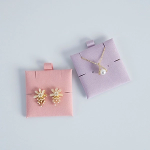 Detail view of floral earrings and pearl necklace displayed on velvet jewelry cards
