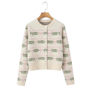 Close-up of cream knit cardigan with pink bows and green pine needle jacquard patterns