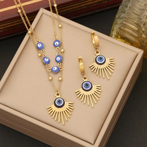 Detail of gold evil eye jewelry set with double layer necklace and earrings in a gift box