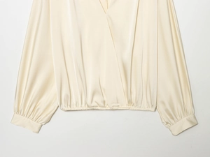 Détail du chemisier cache-cœur en satin avec décolleté en V et taille élastique plissée