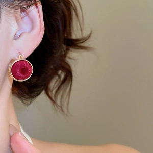 Detailed view of vintage burgundy velvet round earrings with elegant gold metal trim