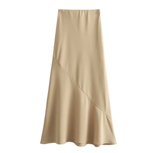 Close-up of champagne satin midi skirt showing smooth silk texture and diagonal stitching