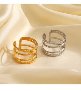 Detailed close-up of gold and silver layered rings with twist design on beige satin