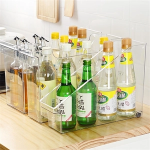 Clear rolling kitchen storage box on wooden countertop for seasoning bottles organizer