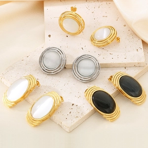 Detail showing gold and silver textured earrings with oval cat eye stones on stone steps